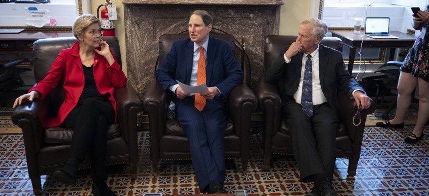 (L-R) Sen. Elizabeth Warren (D-MA), Sen. Ron Wyden (D-OR) and Sen. Angus King (I-ME) speak to reporters about a corporate minimum tax plan at the U.S. Capitol October 26, 2021 in Washington, DC.