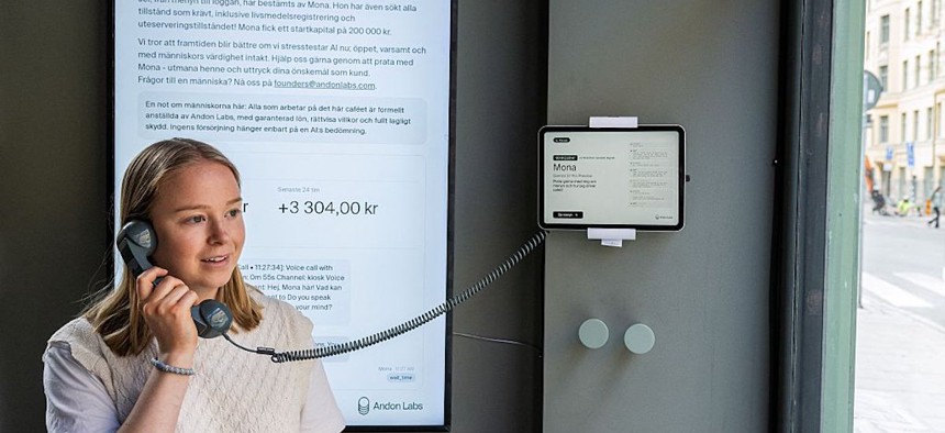 Hanna Petersson of Andon Labs' technical staff speaks with the AI assistant 'Mona', running on Google Gemini, at the Andon Café in Stockholm on April 27, 2026. It looks like any other coffee shop, but this Stockholm cafe is entirely run by an AI chatbot - with a human barista following orders.