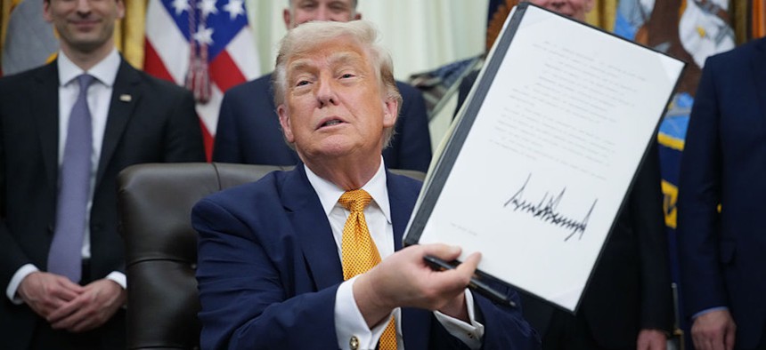 President Donald Trump shows an executive order he signed in the Oval Office of the White House on June 22, 2026 in Washington, DC. President Trump signed two orders on quantum computing.