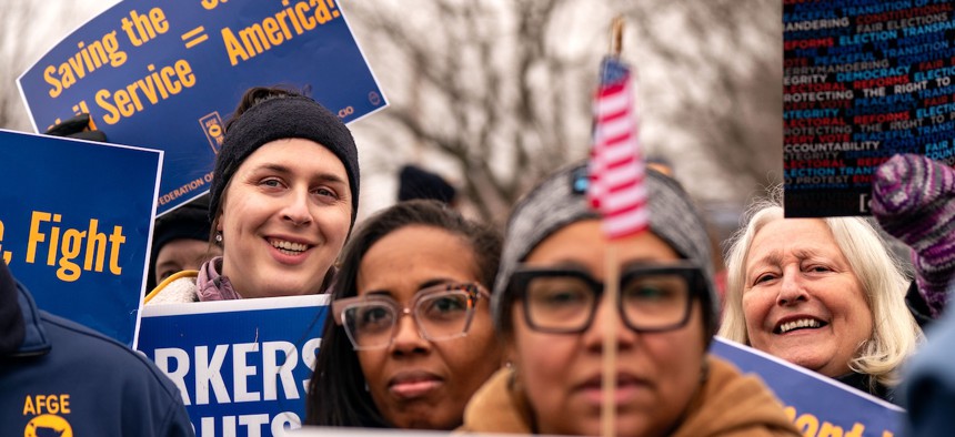 People hold signs as they gather for a "Save the Civil Service" rally hosted by the American Federation of Government Employees (AFGE) outside the U.S. Capitol on Feb. 11, 2025. A recent study by University of Maryland labor economist Brandon Enriquez found that DOGE cuts “disproportionately affected” the federal employment of Black women compared with other demographic groups.