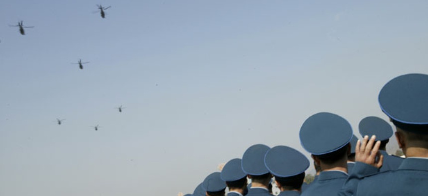 Chinese People's Liberation Army Air Force officers watch helicopters during a celebration.