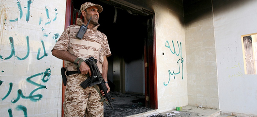 A Libyan military guard stands in front of one of the U.S. Consulate's burnt out buildings.