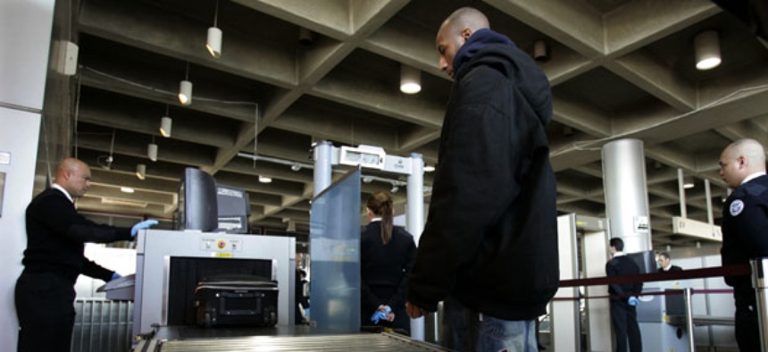 A Homeland Security screener looks at an X-ray scan of a suitcase of a train passenger in 2006.