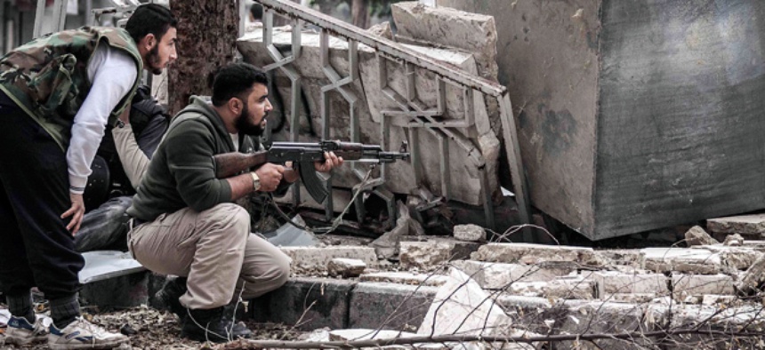 Syrian rebel fighters take cover in southeast Aleppo.