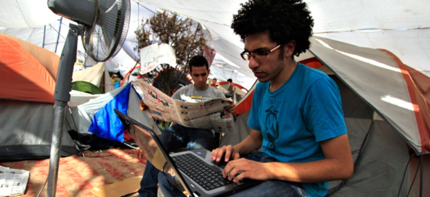 An Egyptian protester uses his laptop next to a cooling fan in Cairo's Tahrir Square in July 2011.