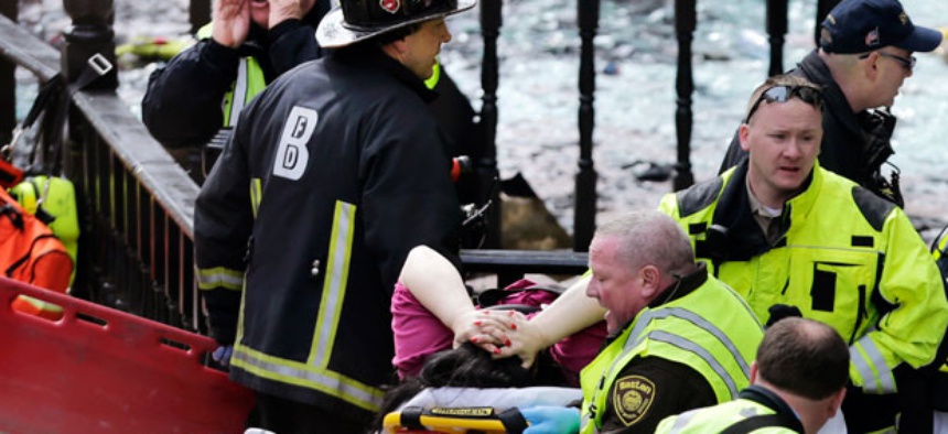 Workers aid an injured woman at the scene of the blast Monday