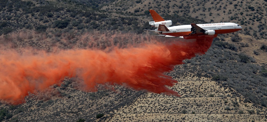 A DC-10 aerial tanker drops a line of fire retardant along the foothills of the Angeles National Forest Sunday.