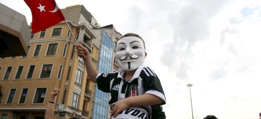 A boy on a man's shoulders wears a Guy Fawkes mask during the third day of anti-government protests in Istanbul.