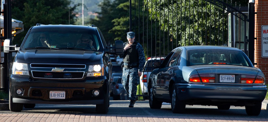 A member of the Navy checks vehicles at a gate to the Washington Navy Yard.
