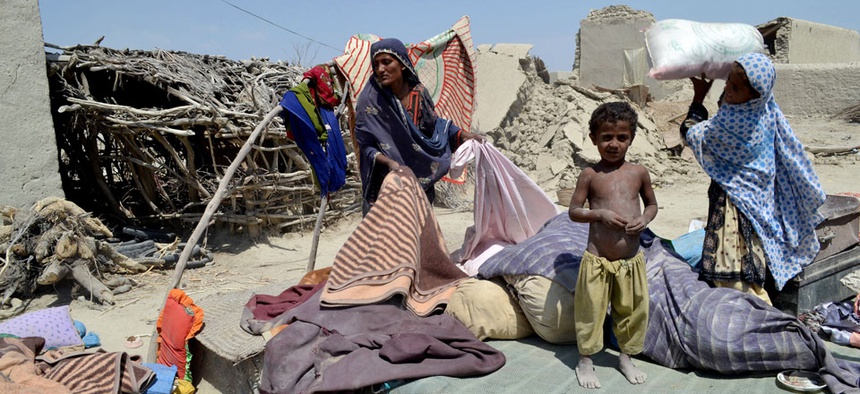 Pakistani villagers collect belongings from their destroyed homes following an earthquake in Labach, Pakistan.