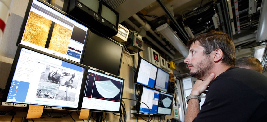 A NOAA employee analyzes data from a sonar system. Roughly half of NOAA employees have been furloughed during the government shutdown