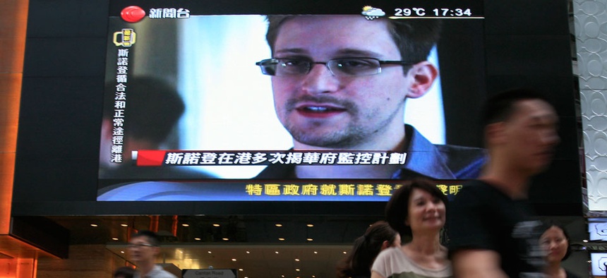 A TV screen shows a news report of Edward Snowden in Hong Kong in June.