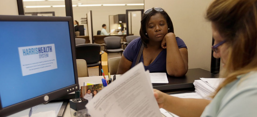 Lillian Ardon, right, of Harris Health System, helps Vanessa Danielle Cotton, left, with her Affordable Care Act marketplace application on Oct. 1.