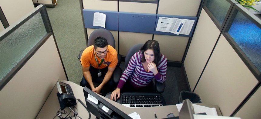 insurance exchange representatives Carlos Villanueva, left, and Emily Joyce prepare for the Oct. 1 open enrollment debut.
