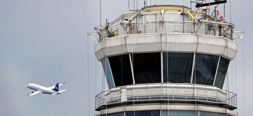 A passenger jet flies past the FAA control tower at Washington's Ronald Reagan National Airport.