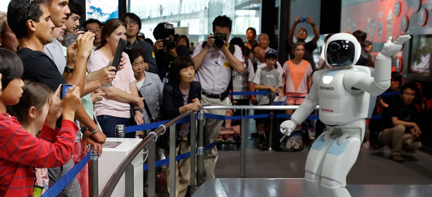 Honda Motor Co.’s interactive robot Asimo gestures while talking with visitors at a demonstration.