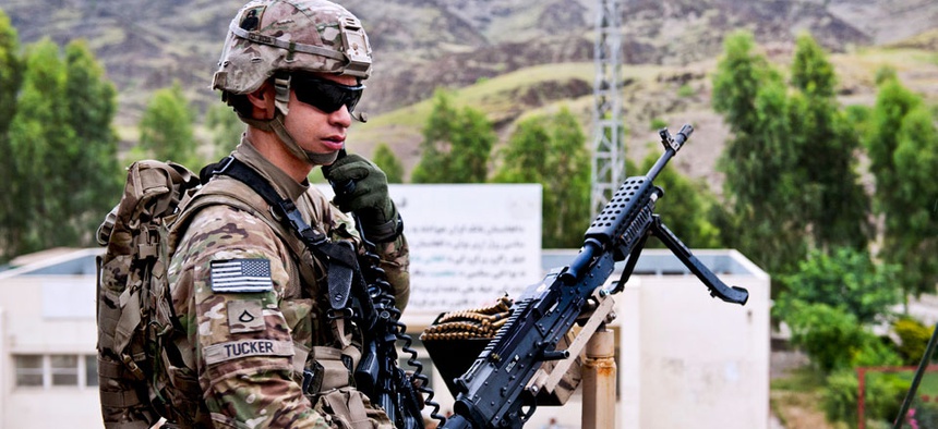 U.S. Army Pfc. Robert Tucker talks on his radio while providing rooftop security for the customs checkpoint at Torkham Gate in Afghanistan's Nangarhar province, April 24, 2013.