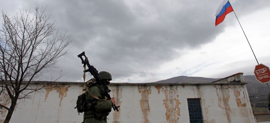 A Russian soldier marches as he and comrades block the Ukrainian infantry base in Perevalne, Ukraine, Tuesday, March 4, 2014.