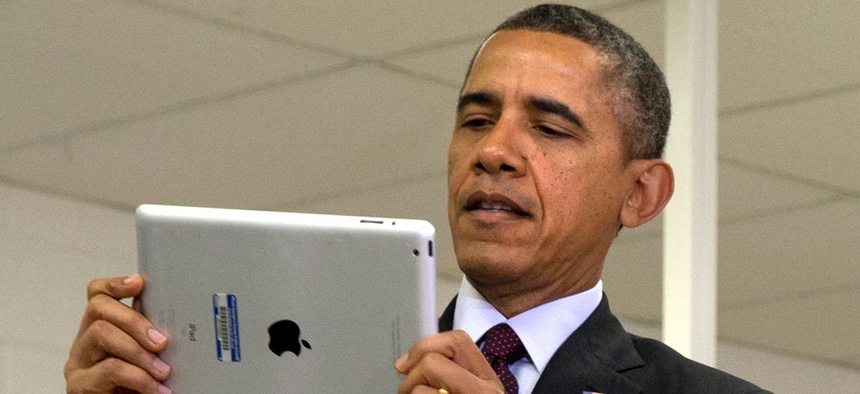 Barack Obama holds an iPad at an event at a Maryland school in February.