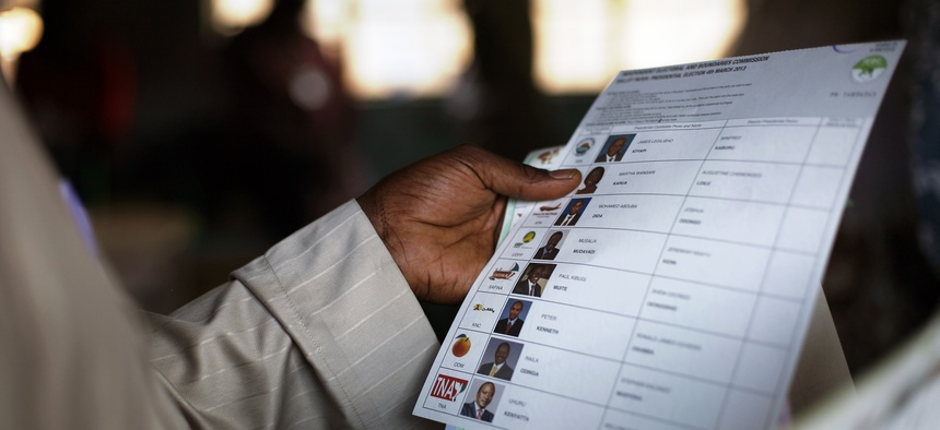 A Kenyan voter holds a presidential ballot at a polling station in 2013.