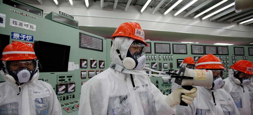 A staff member of the Tokyo Electric Power Co. measures radiation levels inside the central control room of the No. 1 and No. 2 reactors at the Fukushima Dai-ichi nuclear power plant.