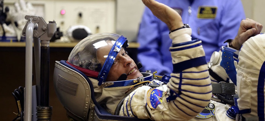 U.S. astronaut Steven Swanson, a crew member of the mission to the ISS, tests a space suit during pre-launch preparations.
