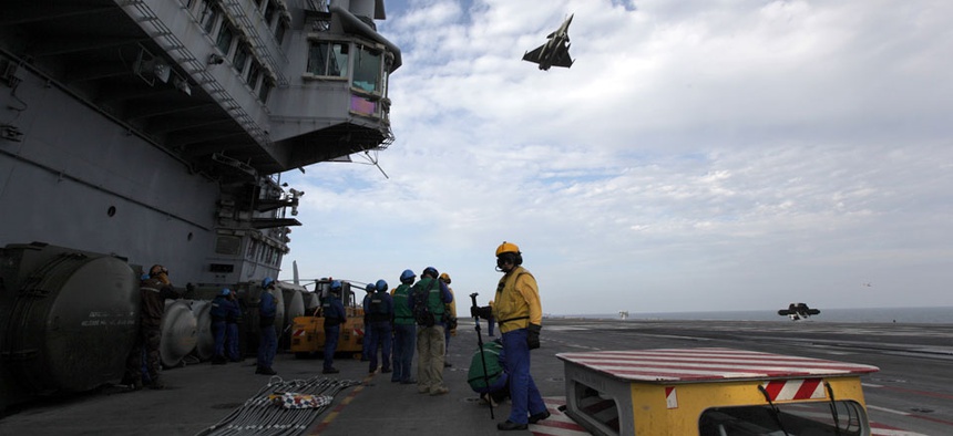A French military plane flies over the USS Harry S. Truman aircraft carrier in the Gulf of Oman.
