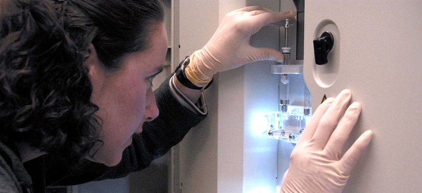 A researcher monitors a DNA sequencing machine at the NIH in Bethesda, Md.