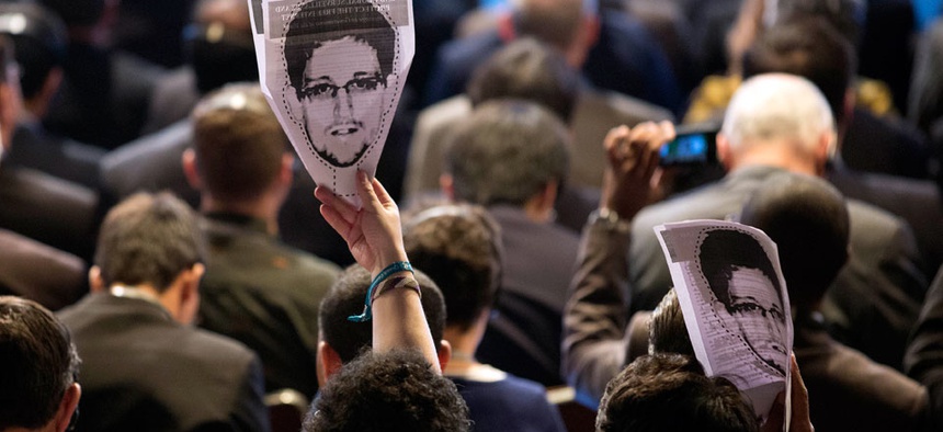 Participants hold up images of former NSA analyst Edward Snowden during the opening ceremony of NETmundial, a major conference on the future of Internet governance in Sao Paulo, Brazil.