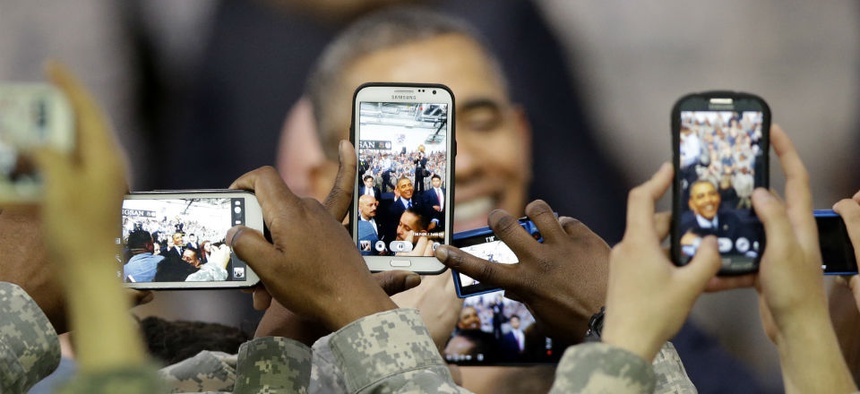 U.S. military soldiers using their smartphones take pictures of President Barack Obama.