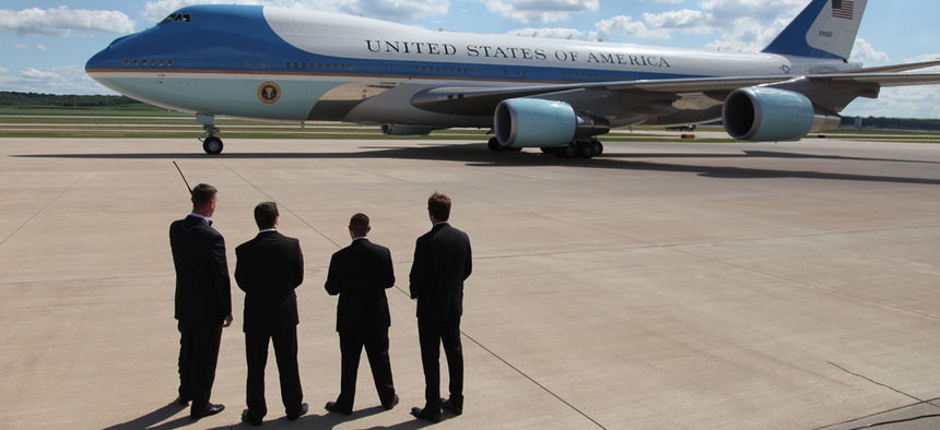 Secret Service agents watch as President Barack Obama leaves on Air Force One in 2013.