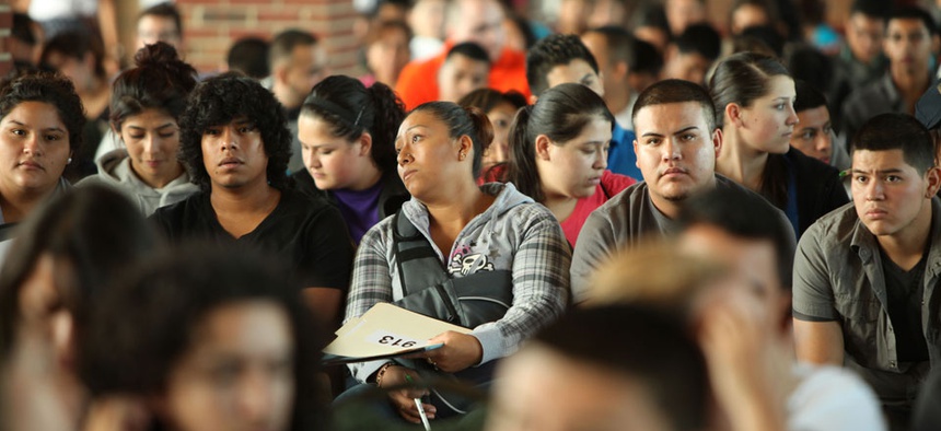 Undocumented people wait to fill out application forms for the Obama administration's Deferred Action for Childhood Arrivals program.