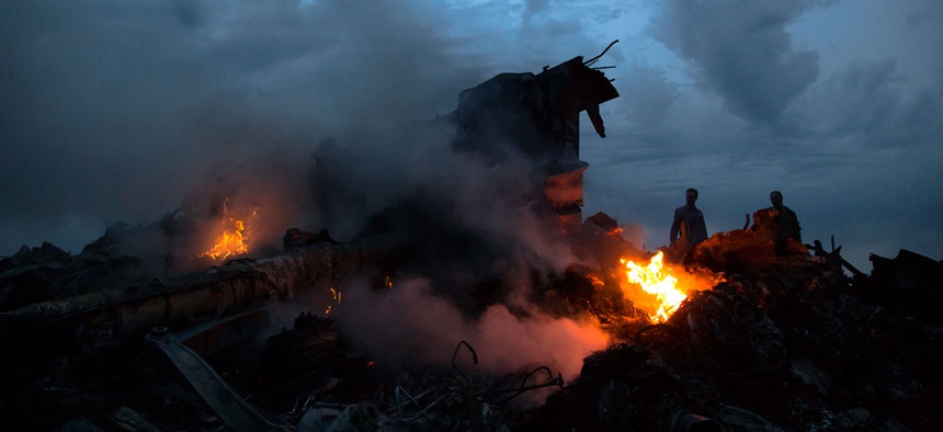 People walking amongst burning debris at the crash site of Malaysia Airlines Flight 17 near the village of Hrabove, eastern Ukraine.