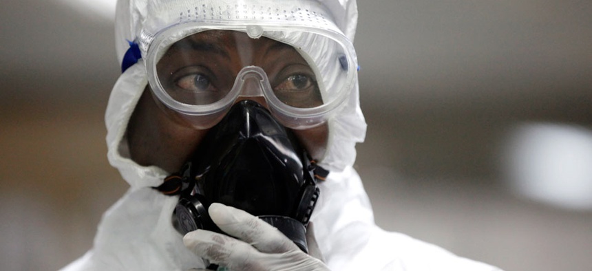 A Nigerian health official wearing a protective suit waits to screen passengers at the arrivals hall of Murtala Muhammed International Airport in Lagos, Nigeria.