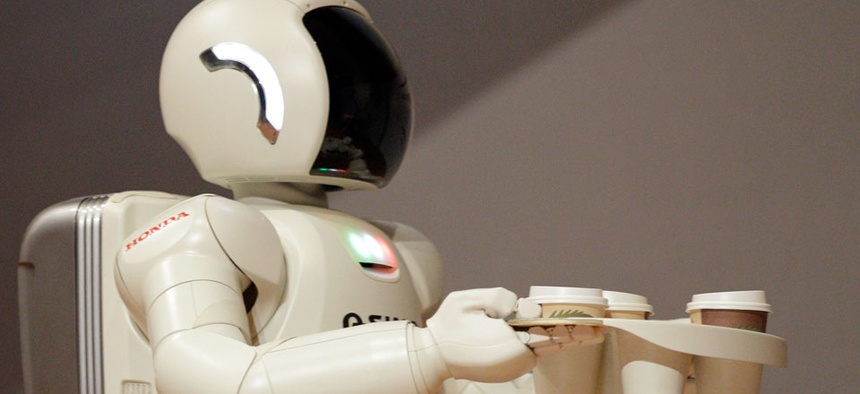 Honda Motors' humanoid robot ASIMO carries coffee.