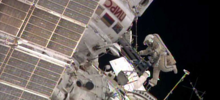 While Flight Engineer Alexander Skvortsov retrieves hardware inside the International Space Station's Pirs airlock, Flight Engineer Oleg Artemyev stretches his legs.