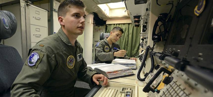 2nd Lt. Oliver Parsons, left, and 1st Lt. Andy Parthum check systems in the underground control room at an ICBM launch control facility near Minot, N.D., in June. 