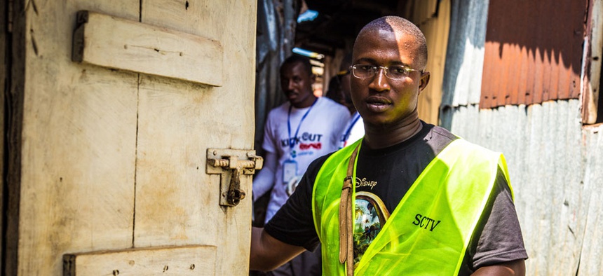 A health worker volunteers distribute bars of soap and information about Ebola in Freetown, Sierra Leone, Saturday, Sept. 20, 2014.