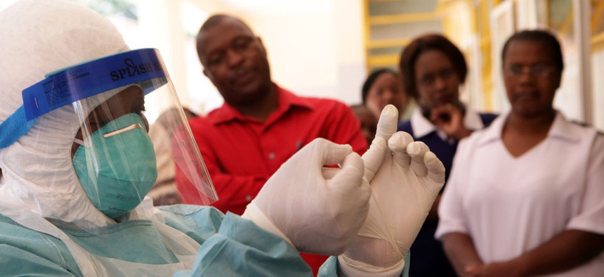 A woman wears protective clothing during a tour of one of the Ebola Centers in Harare, Zimbabwe.