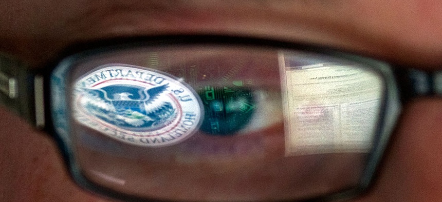 A reflection of the Department of Homeland Security logo in the eyeglasses of a cybersecurity analyst at the watch and warning center of the Department of Homeland Security's secretive cyber defense facility in Idaho Falls, Idaho.