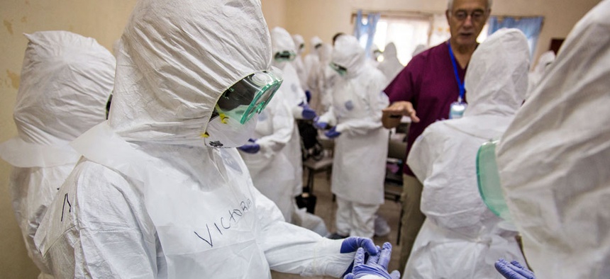 A World Health Organization, WHO, worker, right rear, trains nurses to use Ebola protective gear in Freetown, Sierra Leone.