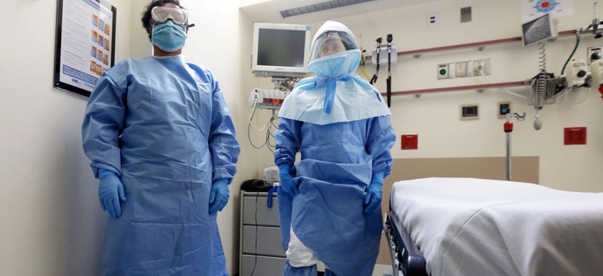 Bellevue Hospital nurse Belkys Fortune, left, and Teressa Celia, Associate Director of Infection Prevention and Control, pose in protective suits in the Emergency Room, during a demonstration of procedures for possible Ebola patients.
