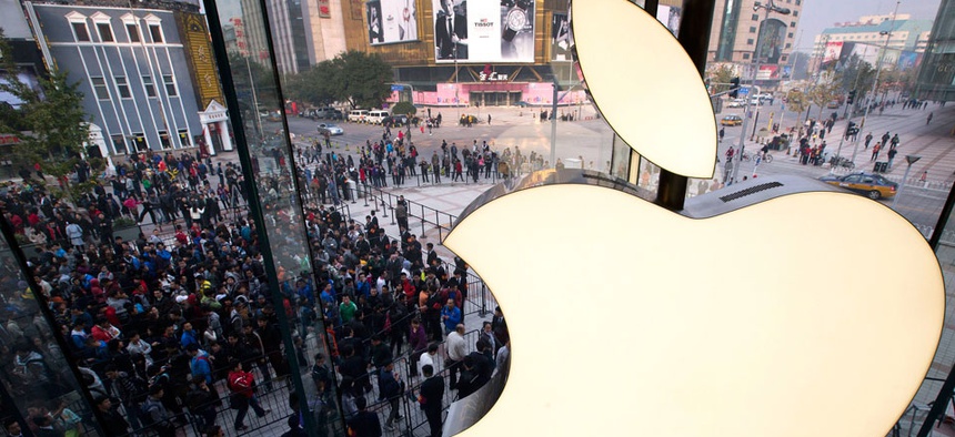 People line up to enter a newly-opened Apple Store in Wangfujing shopping district in Beijing.