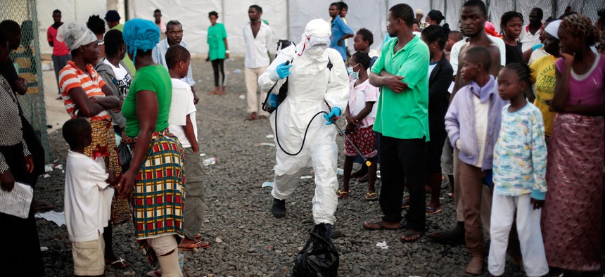 A medical worker sprays people being discharged from the Island Clinic Ebola treatment center in Monrovia, Liberia.