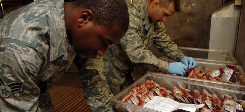 Senior Airman Kendall Thomas, 379th Expeditionary Medical Group Blood Trans-shipment Center laboratory technician, and Maj. Brian Dart, 379th MDG BTC chief, verify blood products before shipment.