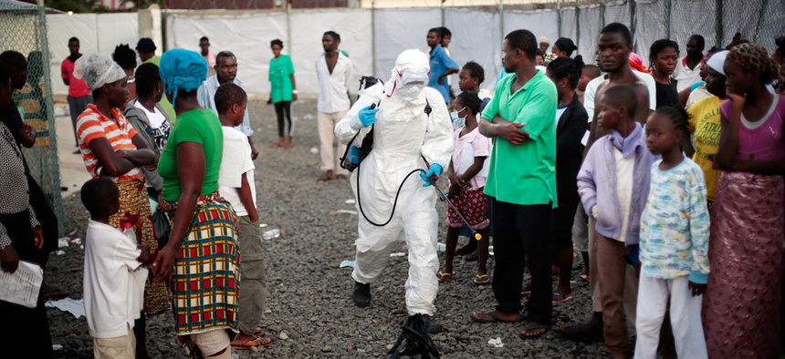 A medical worker sprays people being discharged from the Island Clinic Ebola treatment center in Monrovia, Liberia.
