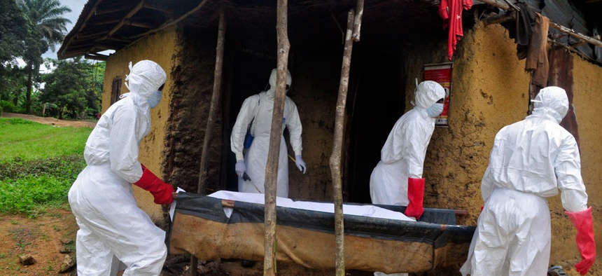 Health workers carry the body of a old man from his house as he is suspected of dying from the Ebola virus in the Siah Town area on the outskirts of Monrovia, Liberia.