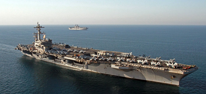 The amphibious assault ship USS Makin Island, background, pulls alongside the aircraft carrier USS George H.W. Bush in the Persian Gulf.