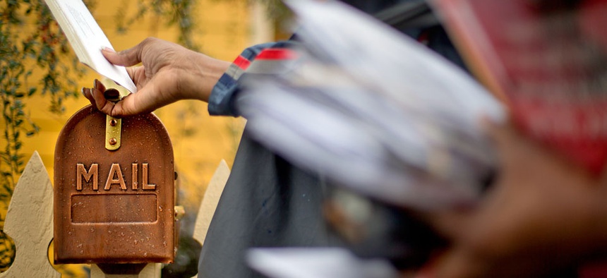 U.S. Postal Service letter carrier, Jamesa Euler, delivers mail, in Atlanta.