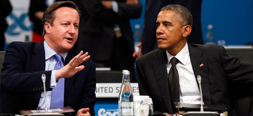 U.S. President Barack Obama, right, and British Prime Minister David Cameron talk at the start of the plenary session at the G20 Summit in Brisbane, Australia Saturday, Nov. 15, 2014.